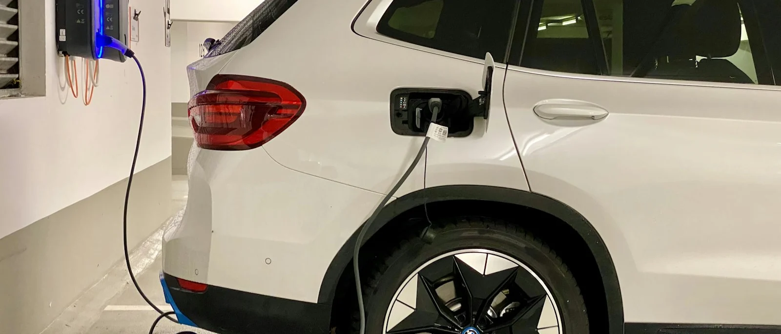 Coche eléctrico enchufado a una estación de carga