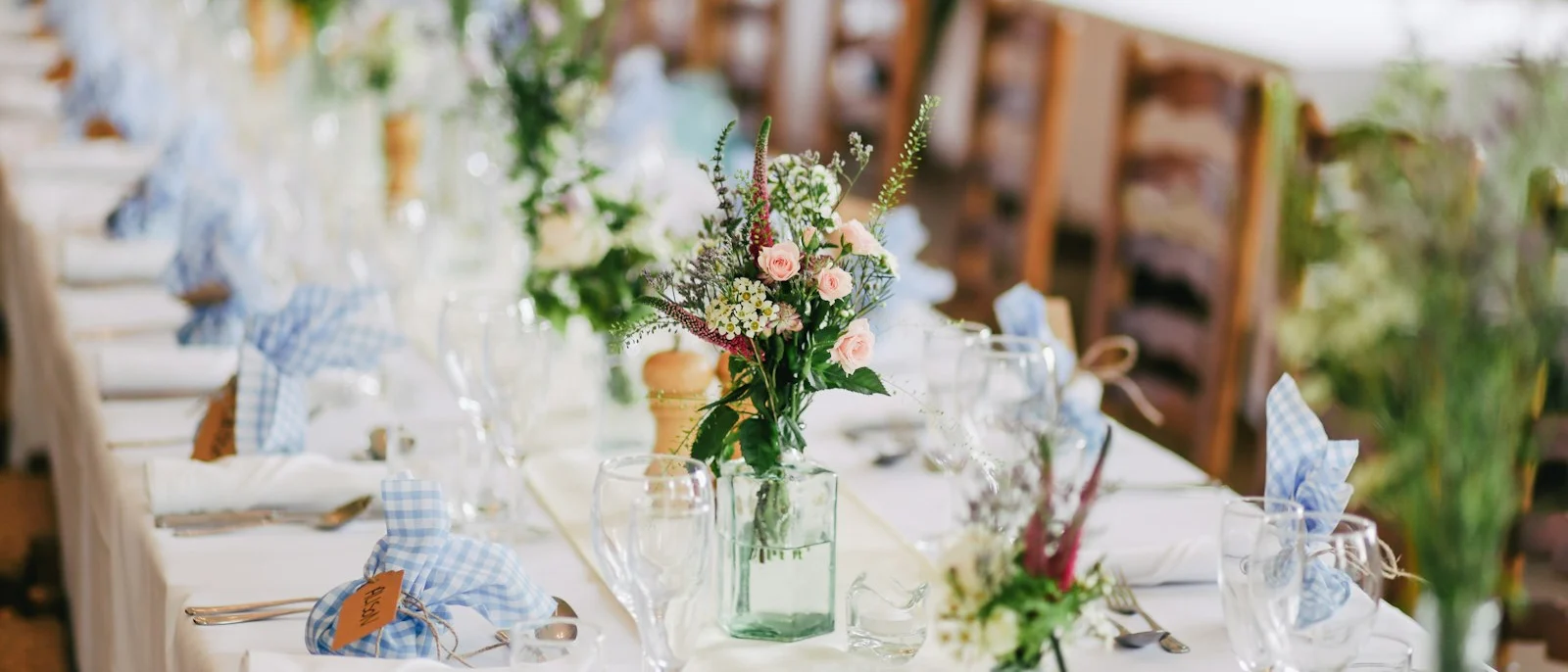 Mesa de banquete de boda con copas y flores
